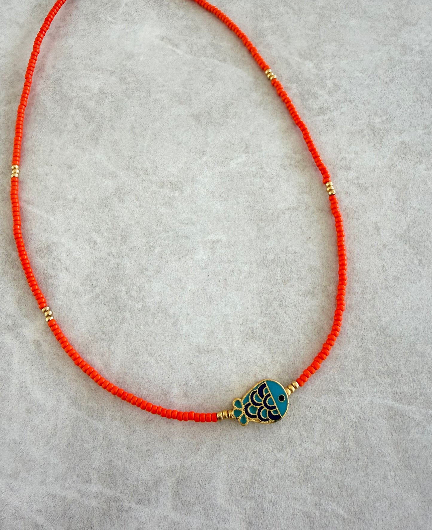 Choker naranja y pez azul