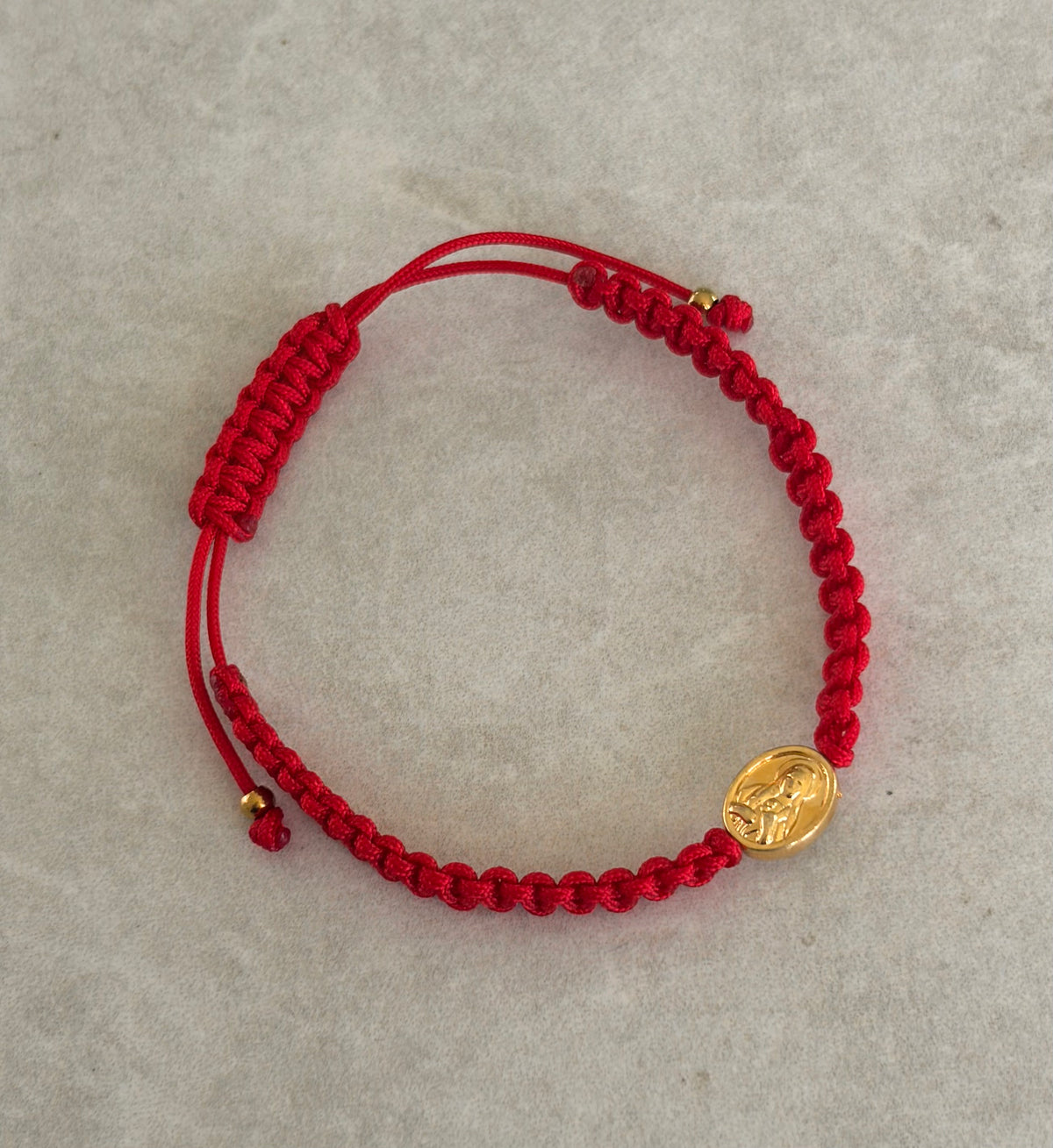 Pulsera San Benito ovalado en hilo rojo