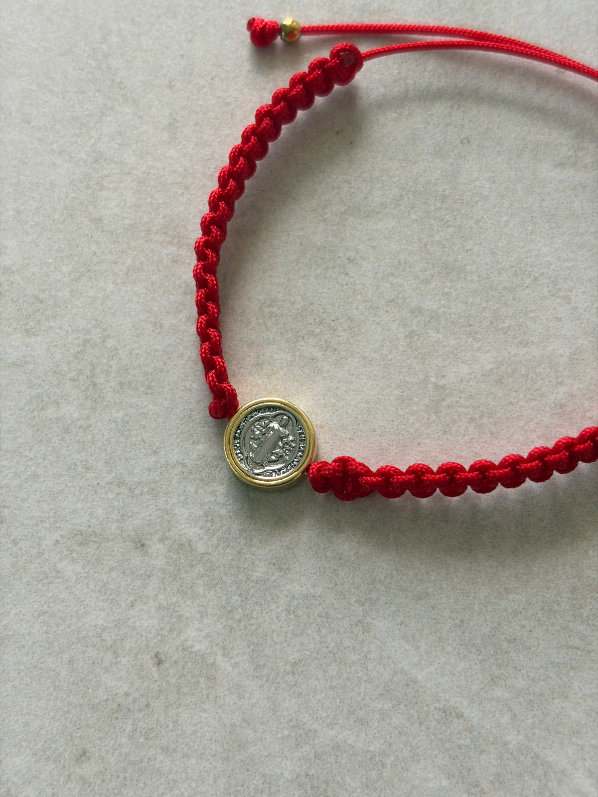 Pulsera San Benito dos tonos en hilo rojo