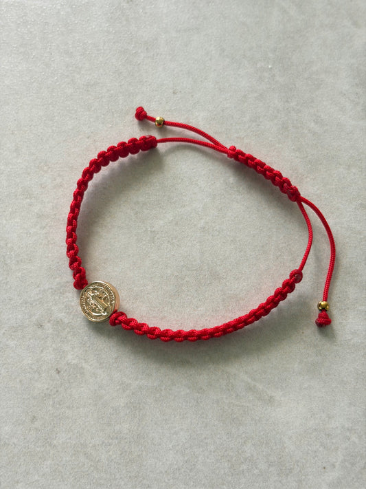 Pulsera San Benito dorada en hilo rojo